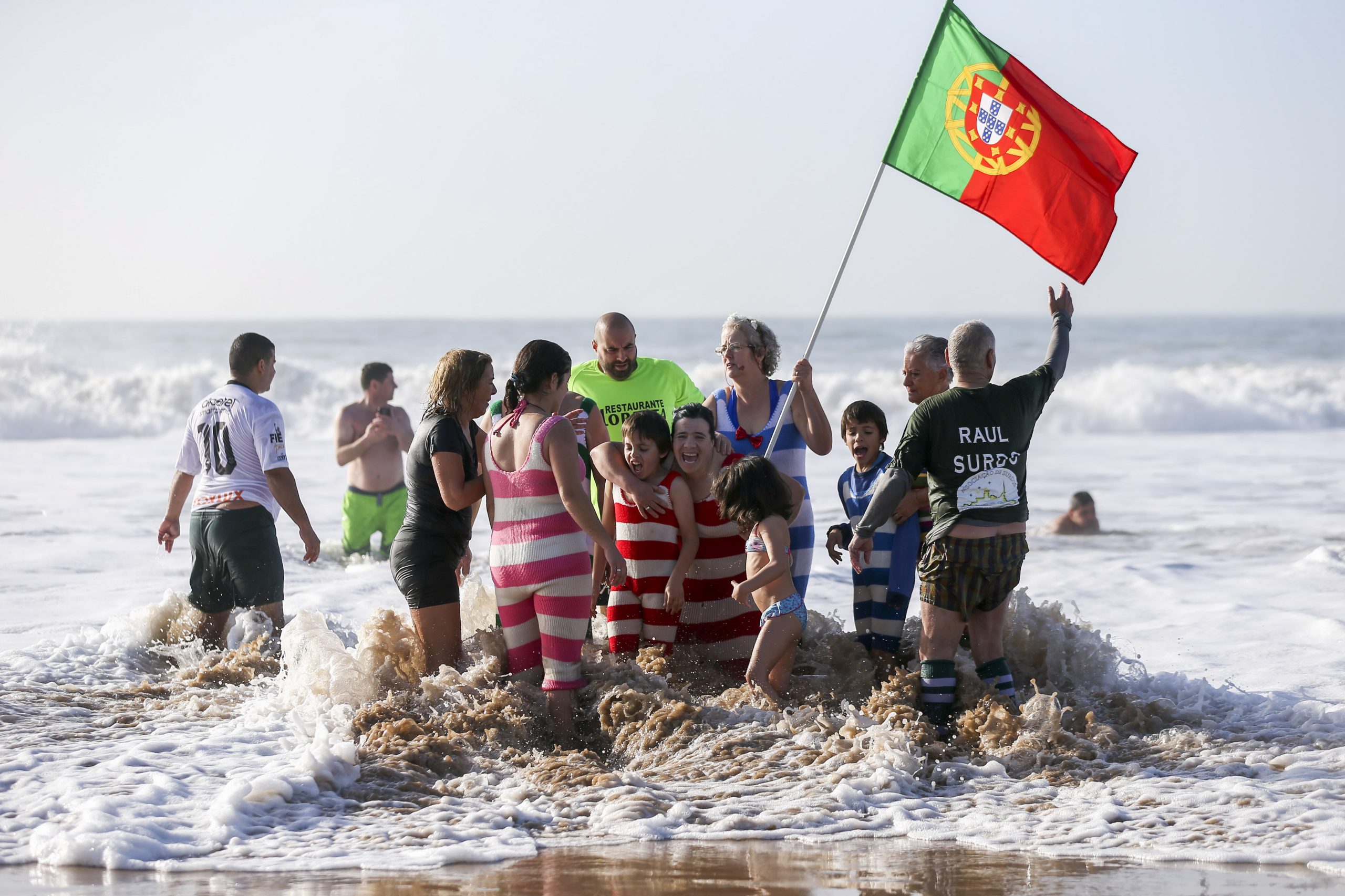 Dezenas cumprem tradição do 1.º banho do ano em Carcavelos, com dia de sol e mar ‘puxado’