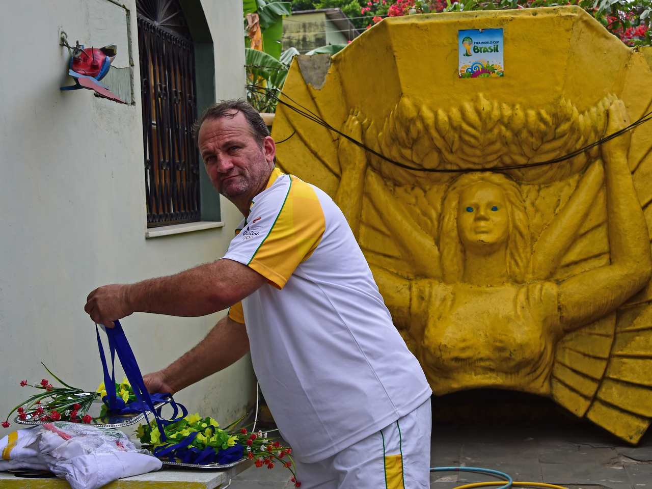 Sports enthusiast Jarbas Meneghini poses inside his house in Campo Grande, Rio de Janeiro, Brazil on August 9, 2016. Menenghini, a 47-year-old mechanic who when he was young wanted to be a footballer, has turned his home into a sort of museum of the Olympic Games and the football World Cup and where every Sunday since last month, the children from the neighborhood gather to play the "Olympic Games". / AFP PHOTO / TASSO MARCELO