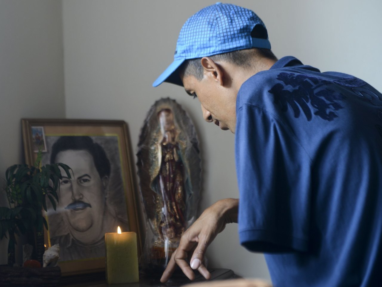 TO GO WITH AFP STORY BY ARIELA NAVARROWberney Zabala, a resident of the Pablo Escobar neighborhood, prays at his house, on November 24, 2013 in Medellin, Antioquia department, Colombia. December 2, 2013 marks the 20th anniversary Escobar's death. AFP PHOTO/Raul ARBOLEDA / AFP PHOTO / RAUL ARBOLEDA