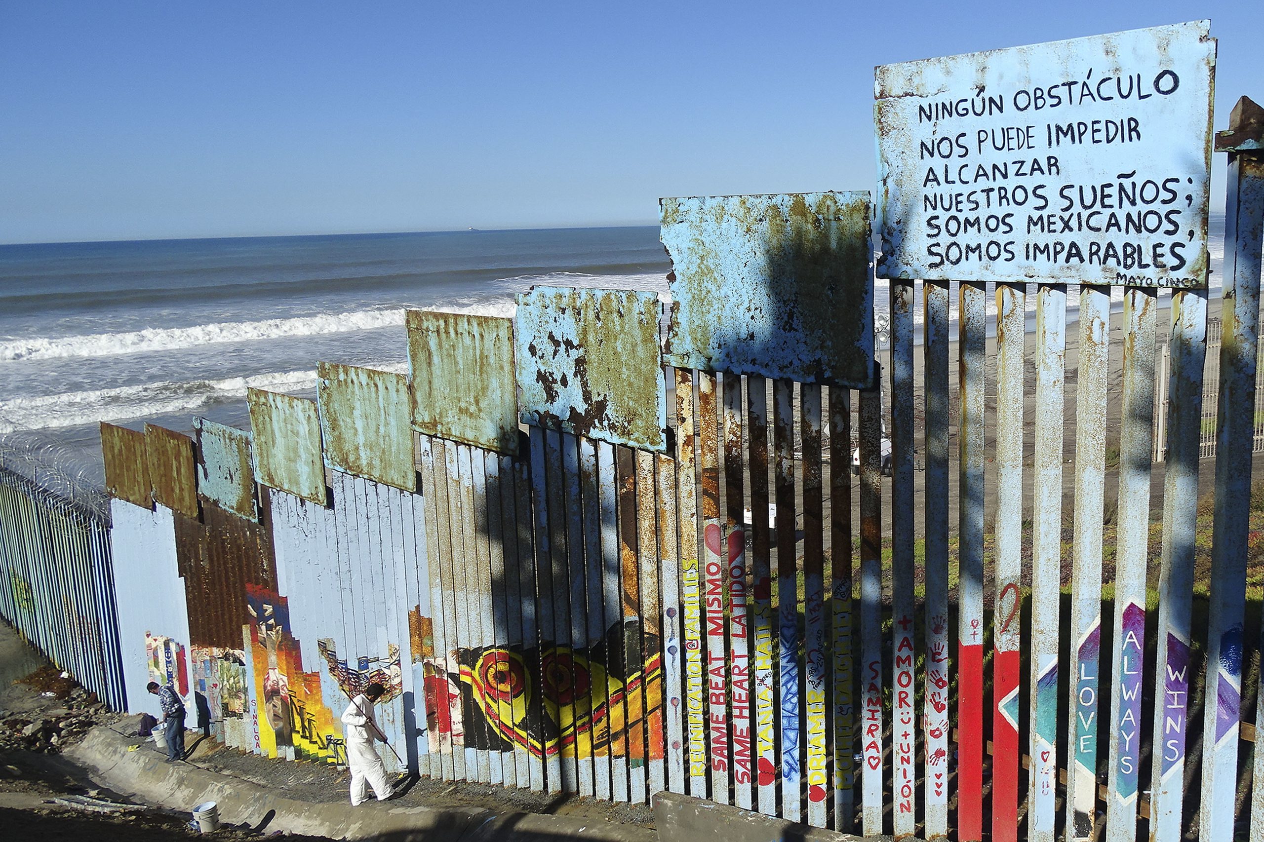 Desafiando as restrições, migrantes tentam atravessar o muro para os EUA