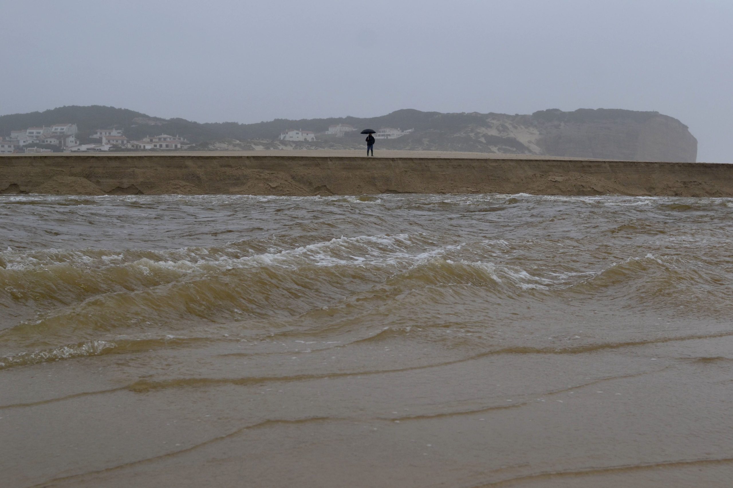 Agitação marítima coloca a descoberto  dezenas de sacas de areia em praia de Óbidos