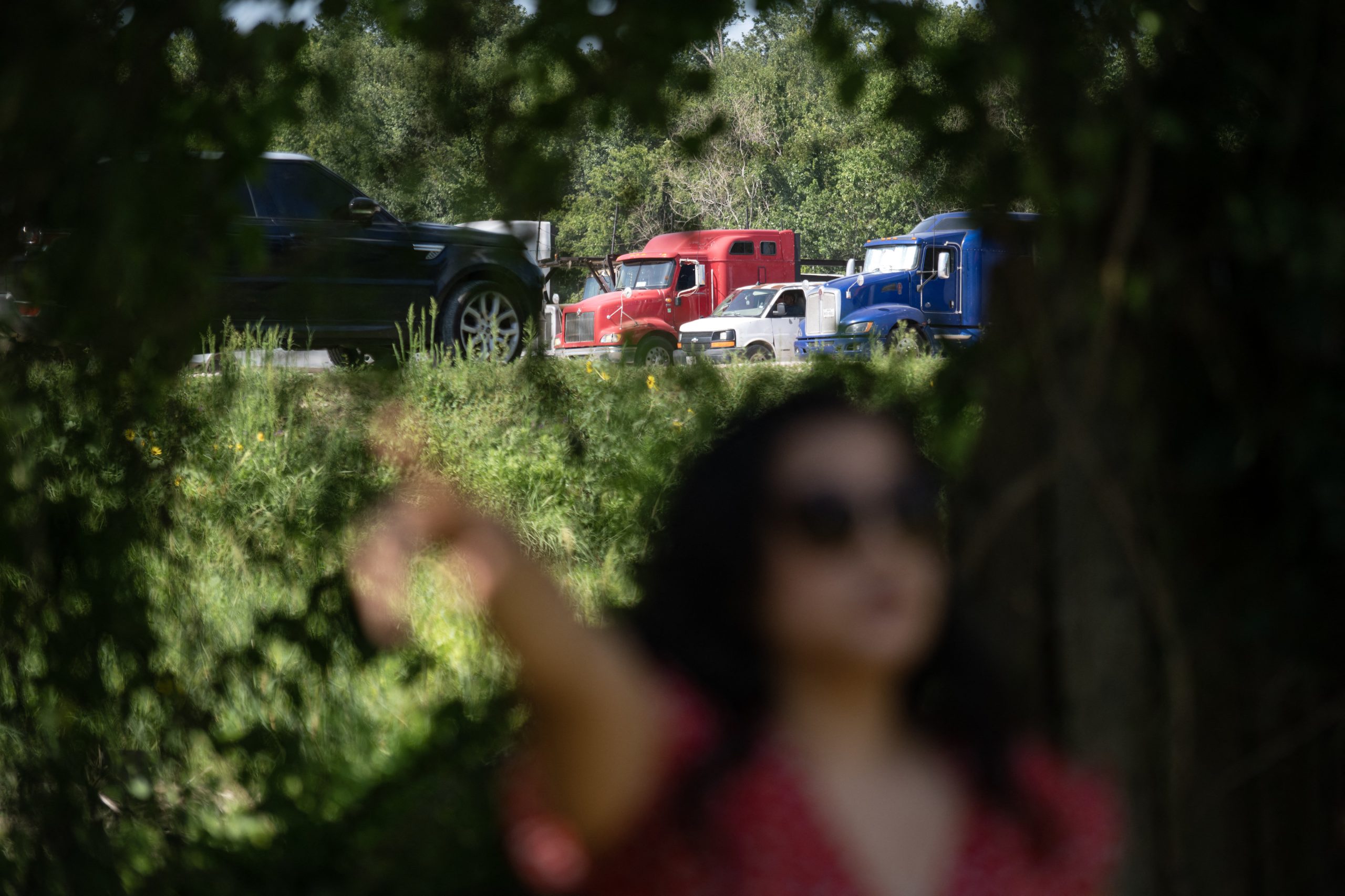 Texas state organizer Erandi Trevino stands on her property next to a parking lot where trucks park long term and idle outside of her home and also Verandi Secret Garden plant nursery in Houston, Texas on June 27, 2023. Extreme temperatures have combined with habitual smog in Houston for more than two weeks, and Erandi Trevino feels the hazardous combination in her body. 